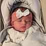baby, blanket, bow, car_seat, close_up, closed_eyes, cozy, face, head_support, headband, infant, newborn, peaceful, pink_headband, plush, portrait, skin, sleeping, soft_fabric, swaddle