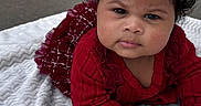 Alani is registered to the contest to win money with this photo: baby, blanket, child, concrete, curly_hair, cute, door, expression, face, fashion, hand, head, infant, outdoor, portrait, red_clothing, skin, toddler, white_bow, young_child