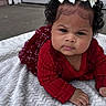baby, blanket, child, concrete, curly_hair, cute, door, expression, face, fashion, hand, head, infant, outdoor, portrait, red_clothing, skin, toddler, white_bow, young_child