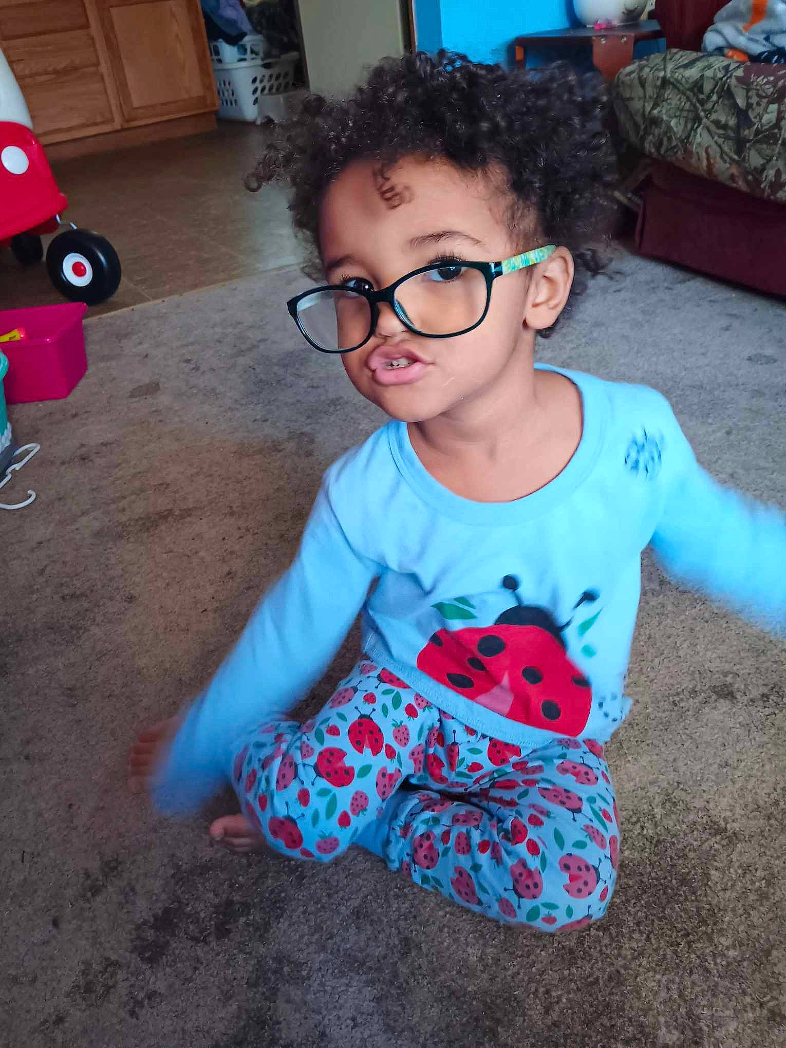 Skylar is registered to the contest to win money with this photo: baby_toddler_clothing, blue, child, cool, electric_blue, eyewear, flooring, fun, hairstyle, happy, head, leisure, pattern, person, sitting, sleeve, standing, t_shirt, toddler, tree