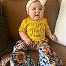 Emily Sophia joined the competition — help win amazing prizes! baby, child, yellow_shirt, headband, bow, pants, floral_pattern, sunflower, sitting, couch, leather, indoor, cute, smiling, person, fashion, infant, colorful_clothing, happy, portrait