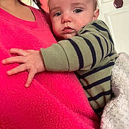 Matthew is registered to the contest to win money with this photo: baby, infant, child, striped_clothing, pink_fleece, blanket, hand, arm, face, eyes, person_holding_child, indoor, door, apple_magnet, cozy, cuddling, portrait, closeup, fleece, sleepy