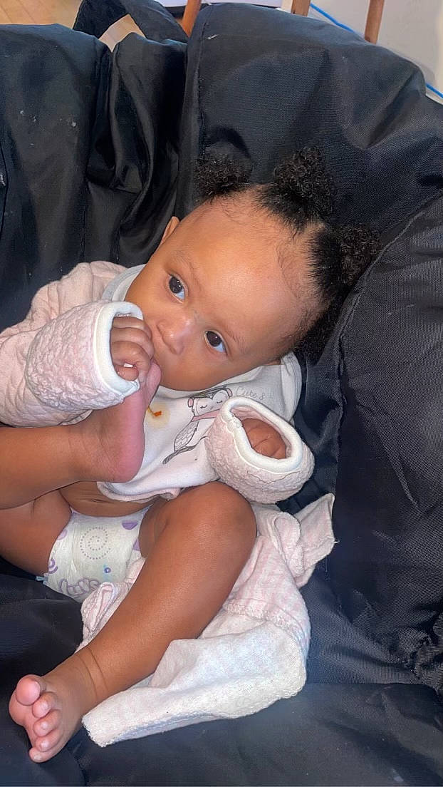 Malia joined the competition — help win amazing prizes! baby, baby_products, baby_toddler_clothing, cheek, child, chin, comfort, event, gesture, hand, human_body, iris, lap, lip, mouth, nail, person, sitting, skin, thumb