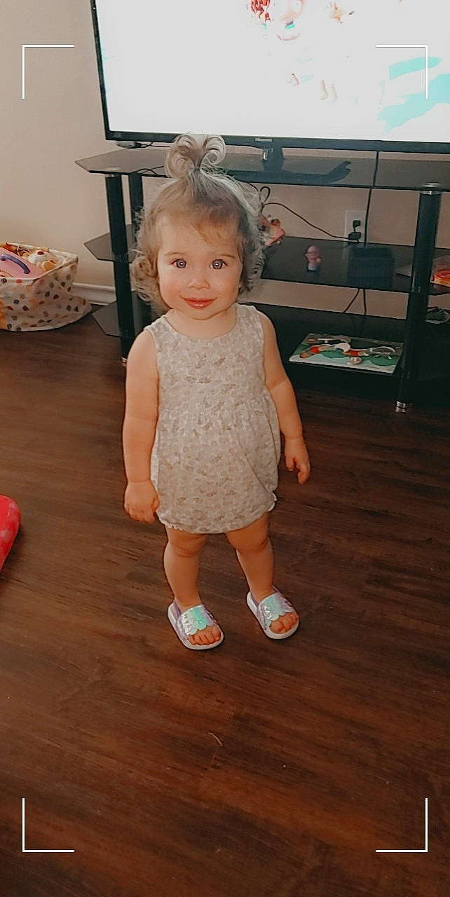 Kamryn is registered to the contest to win money with this photo: baby, baby_toddler_clothing, child, dress, event, floor, flooring, fun, happy, hardwood, human_leg, joy, laptop, leg, person, sitting, skin, smile, toddler, varnish