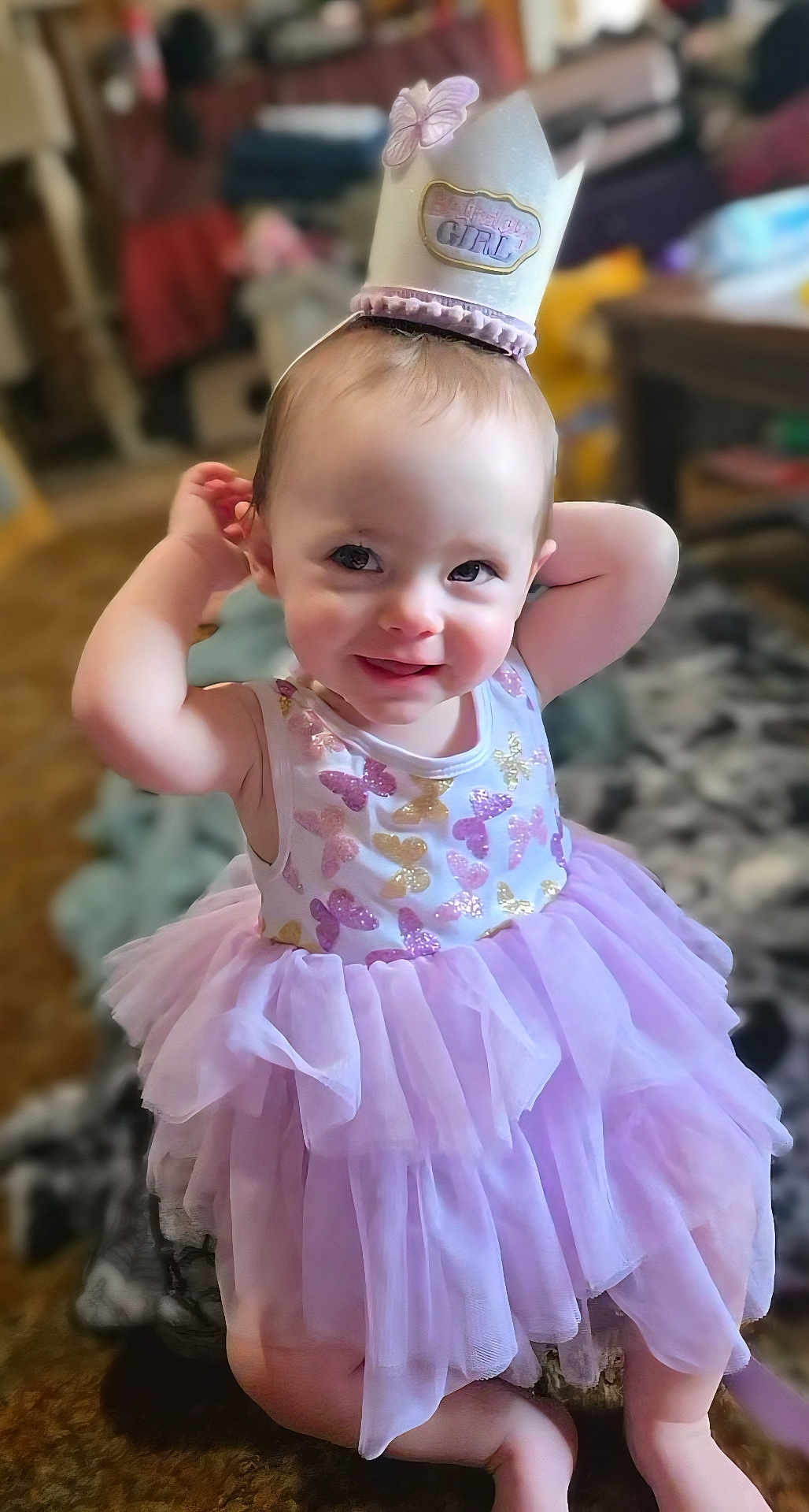 Stella joined the competition — help win amazing prizes! toddler, child, birthday_crown, purple_tutu, butterfly_pattern, smiling, indoor, cute, playful, happy, dress, baby, person, celebration, kneeling, headwear, crown, fashion, portrait, young_child