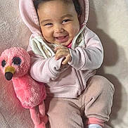 Shiloh joined the competition — help win amazing prizes! baby, smiling, hoodie, plush_toy, pink, cozy, cute, infant, happy, child, soft_texture, socks, flamingo, cuddly, portrait, indoors, clothing, relaxed, seated, toddler