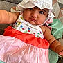 Merxin is registered to the contest to win money with this photo: baby, child, hat, dress, colorful, couch, cushion, pattern, indoors, portrait, cute, infant, sitting, closeup, face, young, smile, skin, arm, textile