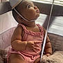 baby, child, party_hat, pink_clothing, plush_toy, playpen, curious, indoor, soft_light, window_blinds, chubby_cheeks, sitting, infant, cute, celebration, pom_pom, looking_up, soft_texture, adorable, young_child