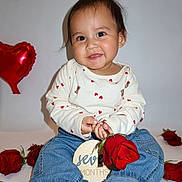 Damian joined the competition — help win amazing prizes! baby, child, rose, red_rose, heart_balloon, balloon, jeans, white_background, barefoot, smiling, portrait, milestone, seven_months, long_sleeve_shirt, heart_pattern, cute, sitting, person, indoor, celebration