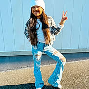 Paige joined the competition — help win amazing prizes! child, girl, smiling, pose, peace_sign, long_hair, white_hat, pom_pom, plaid_jacket, ripped_jeans, blue_jeans, white_shoes, outdoor, sunny, shadow, concrete, wall, fashion, casual, happy