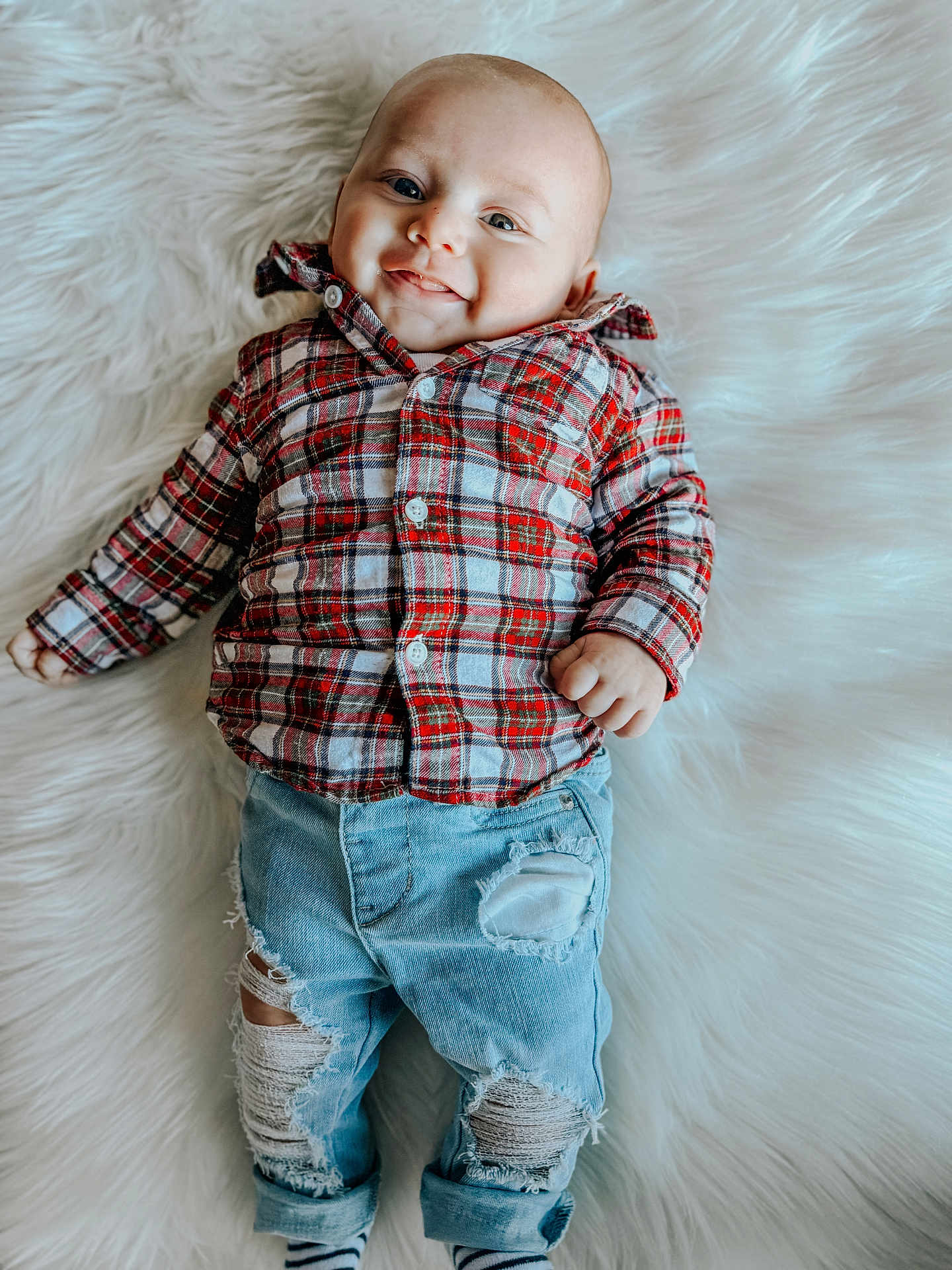 Jayden joined the competition — help win amazing prizes! baby, infant, smile, plaid_shirt, ripped_jeans, denim, fluffy_rug, cute, child, portrait, casual_clothing, happy, lying_down, fashion, young_child, blue_eyes, indoor, cozy, soft_texture, buttoned_shirt