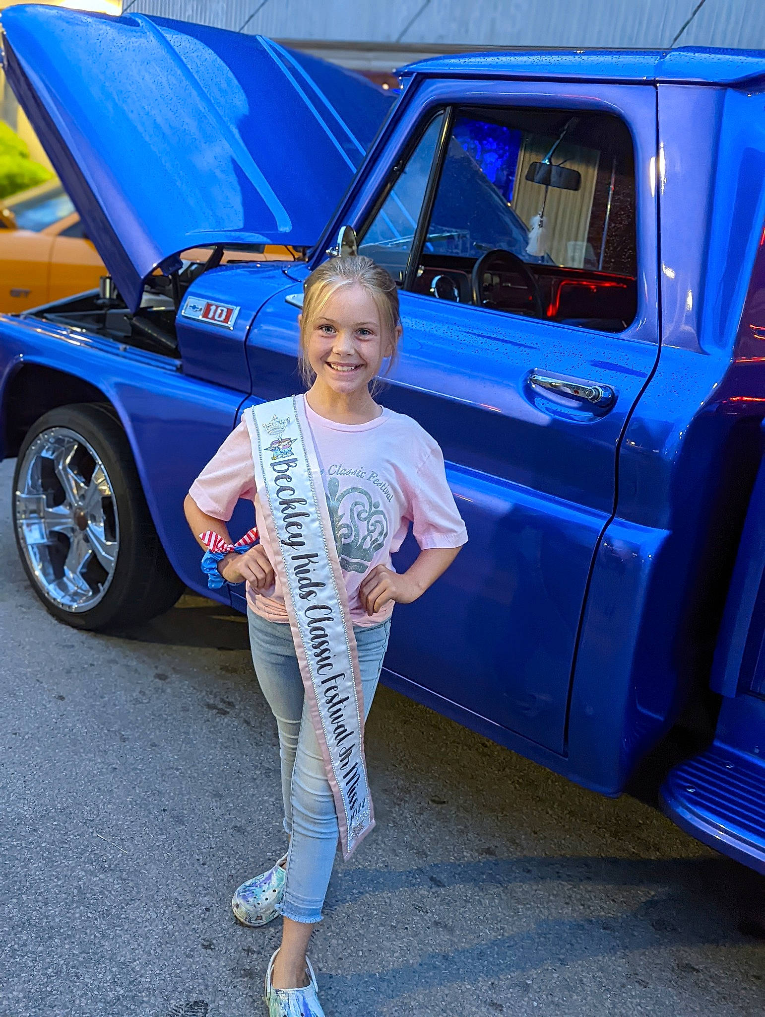 Karly is registered to the contest to win money with this photo: alloy_wheel, automotive_design, automotive_exterior, automotive_lighting, automotive_tire, automotive_wheel_system, blue, bumper, car, electric_blue, fender, hood, joy, motor_vehicle, person, rim, smile, tire, truck, vehicle