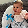 Ellie participe au concours pour gagner de l'argent avec cette photo : baby, infant, blue_bow, white_top, striped_pants, red_hearts, inflatable_ring, blue_bows, couch, grey_couch, indoors, child, cute, smiling, happy, portrait, sitting, face, person, soft_lighting