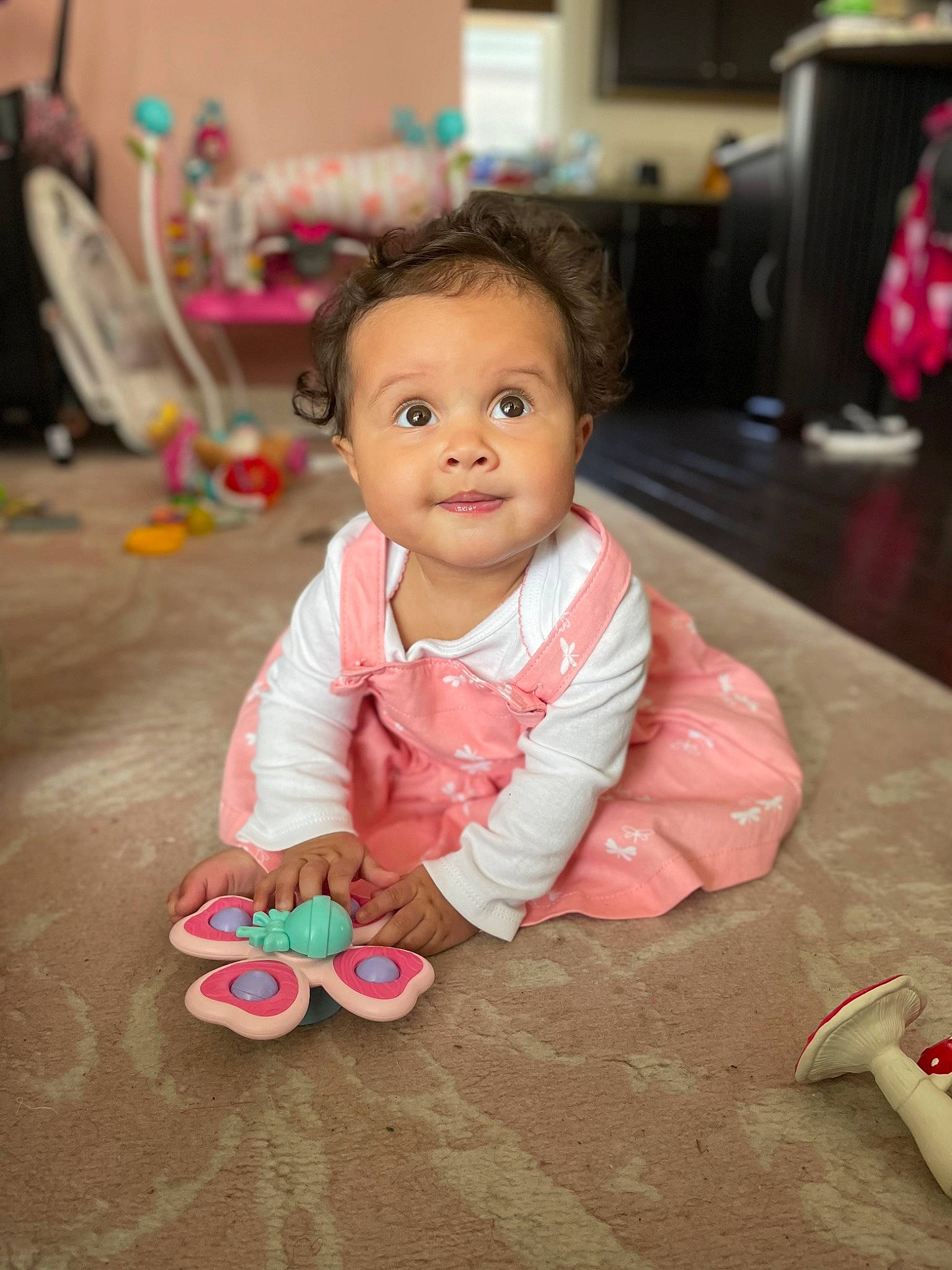 Aviana is registered to the contest to win money with this photo: baby, baby_playing_with_toys, baby_toddler_clothing, cheek, child, floor, flooring, fun, happy, magenta, nose, person, pink, room, sitting, skin, smile, sweetness, television, toddler