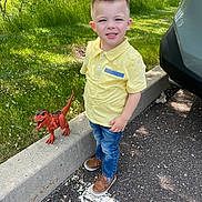 Cameron joined the competition — help win amazing prizes! child, boy, yellow_shirt, toy_dinosaur, sidewalk, curb, grass, car, parking_lot, outdoor, sunlight, jeans, shoes, smile, nature, tree, play, summer, casual, daytime