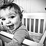 Coralie is registered to the contest to win money with this photo: baby, crib, child, black_and_white, happy, smiling, face, hair, earring, clothing, indoor, portrait, infant, person, cute, expression, young_child, playful, railing, home