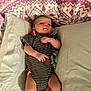 Elijah Davis is registered to the contest to win money with this photo: baby, infant, pillow, blanket, striped_clothing, lying_down, indoor, cute, newborn, soft_texture, patterned_blanket, small_hands, small_legs, face, person, child, resting, cozy, sleepwear, bed
