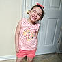 Pheonix is registered to the contest to win money with this photo: child, girl, smiling, indoor, striped_shirt, floral_print, shorts, headband, bow, door, tile_floor, happy, posing, cute, young, person, standing, casual_clothing, playful, portrait
