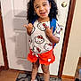 Pheonix joined the competition — help win amazing prizes! child, smiling, standing, indoors, door, backpack, curly_hair, hello_kitty, shorts, tshirt, shoes, floor, rug, wood_floor, home, person, happy, cute, fashion, casual