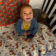 Cade is registered to the contest to win money with this photo: baby, bedroom, blanket, blue_jacket, child, crib, cute, decor, footwear, fox_pattern, furniture, happy, indoors, infant, person, playful, plush_toy, portrait, smiling, yellow_shirt