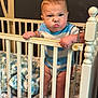 Cade joined the competition — help win amazing prizes! baby, crib, infant, child, furniture, blanket, plush_toy, bunny, expression, determined, standing, grip, railing, indoor, room, wall_art, blue_shirt, diaper, cute, young
