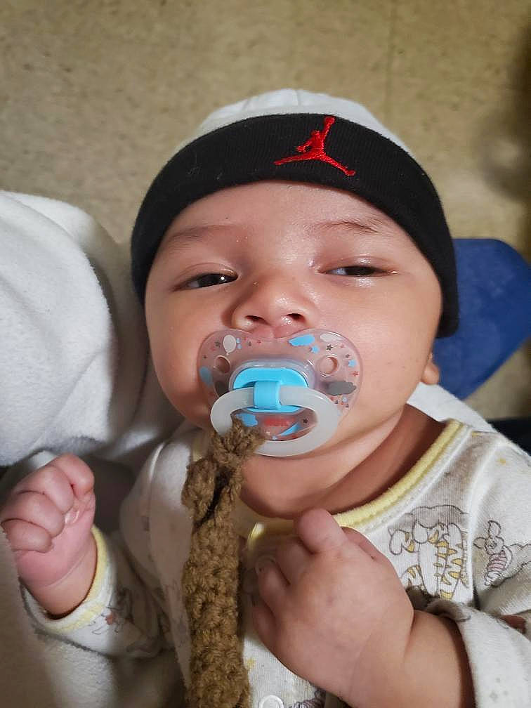 Alijah is registered to the contest to win money with this photo: baby, baby_toddler_clothing, cap, cheek, drinkware, ear, finger, gesture, hand, happy, hat, headwear, iris, lip, mouth, nail, nose, person, plastic_bottle, skin
