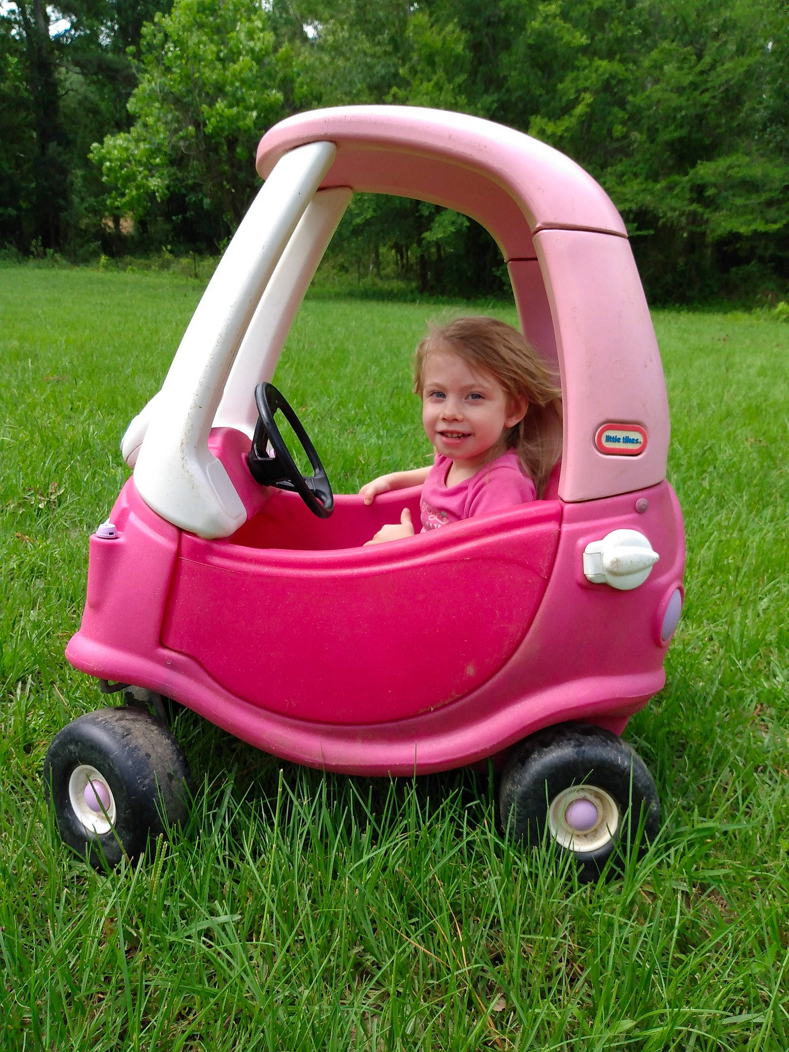 Audrey joined the competition — help win amazing prizes! baby_products, car, child, grass, joy, person, pink, plant, play, product, riding_toy, toddler, vehicle