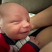 Dawson joined the competition — help win amazing prizes! baby, newborn, smiling, face, closeup, infant, person, red_clothing, striped_clothing, arm, hand, skin, couch, background, comfort, joy, portrait, indoors, cute, happy
