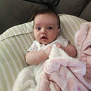 Raider joined the competition — help win amazing prizes! baby, blanket, couch, striped_pillow, infant, soft_texture, cozy, indoor, cute, child, person, clothing, expression, face, head, toddler, comfort, resting, pink, white