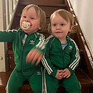 Mateo a rejoint le concours — aidez-le/la à gagner de superbes lots ! toddler, child, stairs, green_tracksuit, adidas, pacifier, indoor, wooden_stairs, sitting, cute, smiling, blond_hair, matching_outfits, person, young_children, casual_clothing, two_children, home, portrait, playful