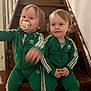 toddler, child, stairs, green_tracksuit, adidas, pacifier, indoor, wooden_stairs, sitting, cute, smiling, blond_hair, matching_outfits, person, young_children, casual_clothing, two_children, home, portrait, playful