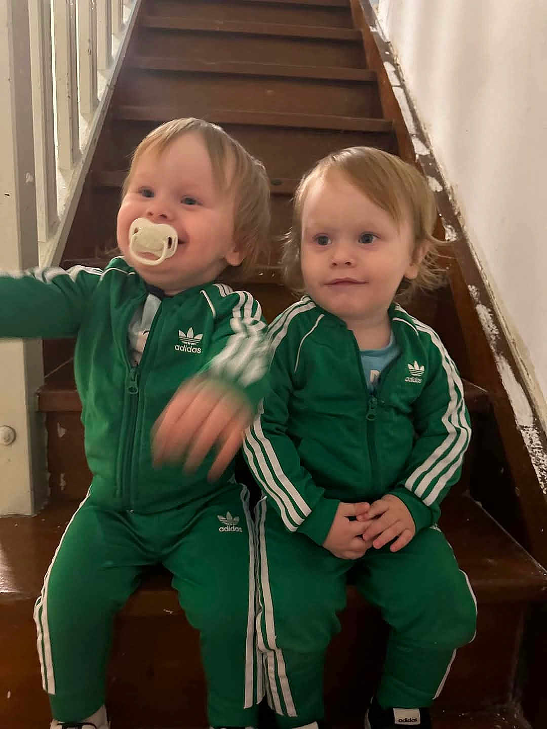 Mateo a rejoint le concours — aidez-le/la à gagner de superbes lots ! toddler, child, stairs, green_tracksuit, adidas, pacifier, indoor, wooden_stairs, sitting, cute, smiling, blond_hair, matching_outfits, person, young_children, casual_clothing, two_children, home, portrait, playful