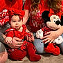 Selena participe au concours pour gagner de l'argent avec cette photo : baby, child, adult, family, christmas, holiday, red_clothing, bow, plush_toy, minnie_mouse, carpet, sitting, holding, smiling, indoor, person, casual, tshirt, jeans, tattoo
