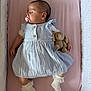 Blue is registered to the contest to win money with this photo: baby, sleeping, pacifier, plush_toy, dress, lace, sock, crib, mattress, pink, blue, infant, child, cute, soft_toy, resting, peaceful, indoor, person, newborn