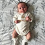 baby, infant, onesie, socks, cute, lying_down, blanket, pattern, soft, adorable, child, young, clothing, portrait, smiling, face, skin, hands, feet, bed