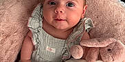 Blue is registered to the contest to win money with this photo: baby, bunny, child, clothing, comfort, cozy, cushion, cute, fabric, face, indoors, infant, person, pink, plush_toy, portrait, rest, sitting, soft, texture