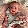 Blue is registered to the contest to win money with this photo: baby, infant, plush_toy, bunny, cushion, pink, soft, comfort, face, person, clothing, sitting, cute, child, portrait, indoors, fabric, texture, rest, cozy