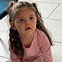 blue_chair, candid, casual, child, curious, expression, floor, furniture, girl, home, indoors, long_hair, natural_light, person, pigtails, pink_clothing, portrait, sitting, tile_floor, young_child