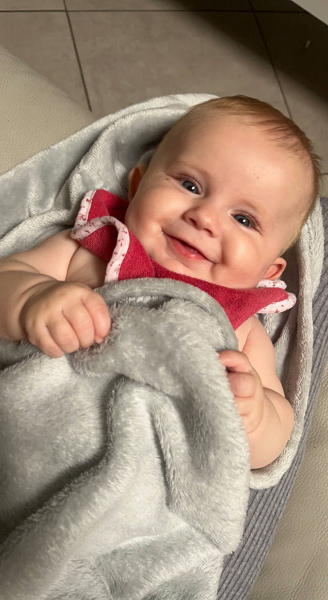 Emy participe au concours pour gagner de l'argent avec cette photo : baby, baby_toddler_clothing, cheek, comfort, finger, gesture, grey, hand, happy, head, human_body, iris, joy, lip, nose, outerwear, person, skin, smile, textile