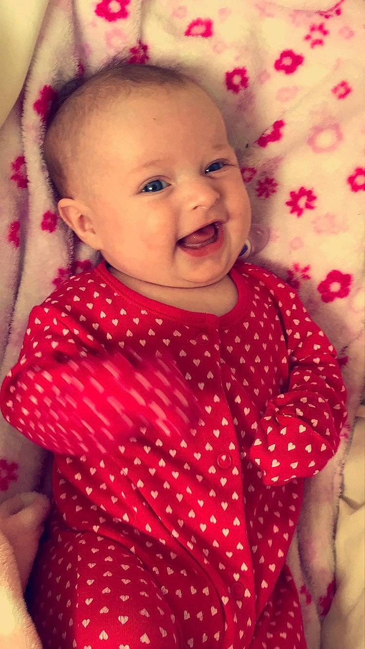 Paisley is registered to the contest to win money with this photo: baby, cheek, child, design, eye, face, facial_expression, fun, happy, head, iris, lip, nose, pattern, person, pink, red, skin, smile, textile