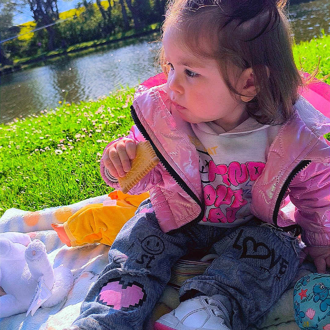 Kataleya participe au concours pour gagner de l'argent avec cette photo : ball, blanket, child, cute, daytime, grass, hair, jacket, jeans, nature, outdoor, park, playtime, pond, shoes, sitting, snack, sunlight, toddler, toy