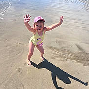 Inaya participe au concours pour gagner de l'argent avec cette photo : child, beach, sand, water, sunny, swimsuit, pink_cap, flamingo, shadow, smiling, joyful, summer, vacation, outdoor, playful, barefoot, shoreline, people, nature, holiday