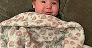 Emily joined the competition — help win amazing prizes! baby, infant, child, portrait, smiling, happy, face, eyes, hair, blanket, fleece, pink, patterned, couch, indoor, sitting, cozy, closeup, photography, home