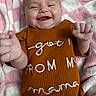 Feya is registered to the contest to win money with this photo: baby, blanket, child, close_up, clothing, cute, embroidered_text, face, hands, happy, infant, lying_down, pink, portrait, ribbed_fabric, rust_color, smiling, soft_texture, text, white