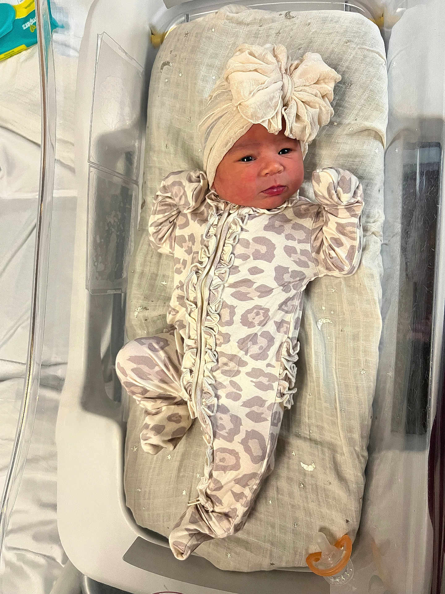 Alaya is registered to the contest to win money with this photo: baby, newborn, infant, onesie, headband, pacifier, bassinet, hospital, blanket, sleepwear, face, person, cute, bed, resting, clothing, soft, indoor, small, child