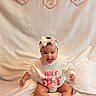 baby, smiling, headband, bow, sweatshirt, pink, white_background, celebration, milestone, sitting, happy, infant, cute, child, portrait, indoors, fabric, clothing, feet, sock