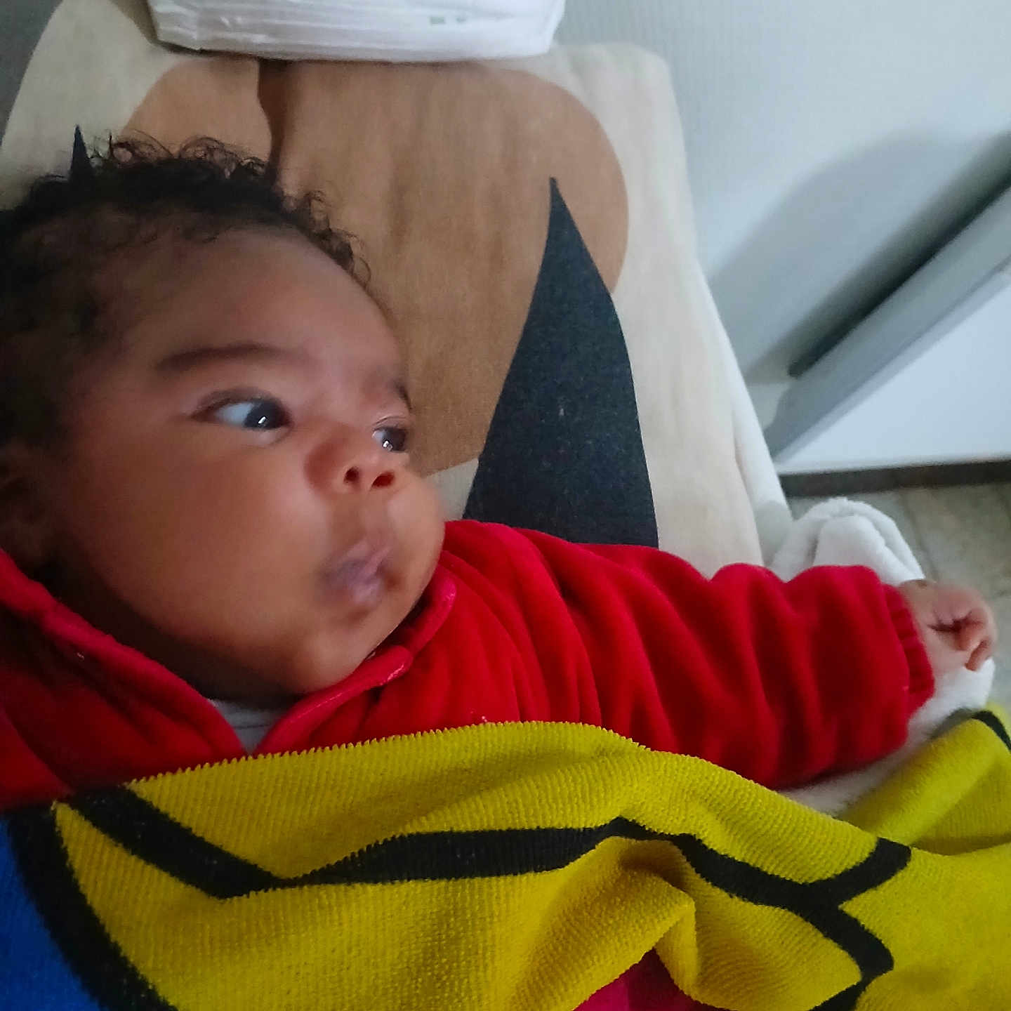 Aly participe au concours pour gagner de l'argent avec cette photo : baby, bed, blanket, child, cozy, curly_hair, cushion, diapers, face, head, indoor, infant, looking_away, person, portrait, red_clothing, sleeping_area, soft_toys, toddler, warm