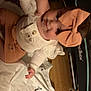 Sage joined the competition — help win amazing prizes! baby, child, infant, bow, headwear, tattoo, arm, blanket, numbers, heart, clothing, indoor, floor, wooden_floor, person, baby_gear, happy, smiling, cute, hand