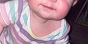 Sage joined the competition — help win amazing prizes! baby, child, face, hand, striped_clothing, onesie, blanket, skull_pattern, smile, cheeks, indoors, person, infant, cute, fingertips, short_hair, candid, closeup, soft_light, expression