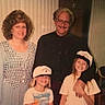 Rufus is registered to the contest to win money with this photo: adults, background, chairs, children, clothing, curtains, dog, family, girls, group_photo, hats, indoor, man, matching_caps, photography, portrait, smiling, vintage, warm_lighting, woman